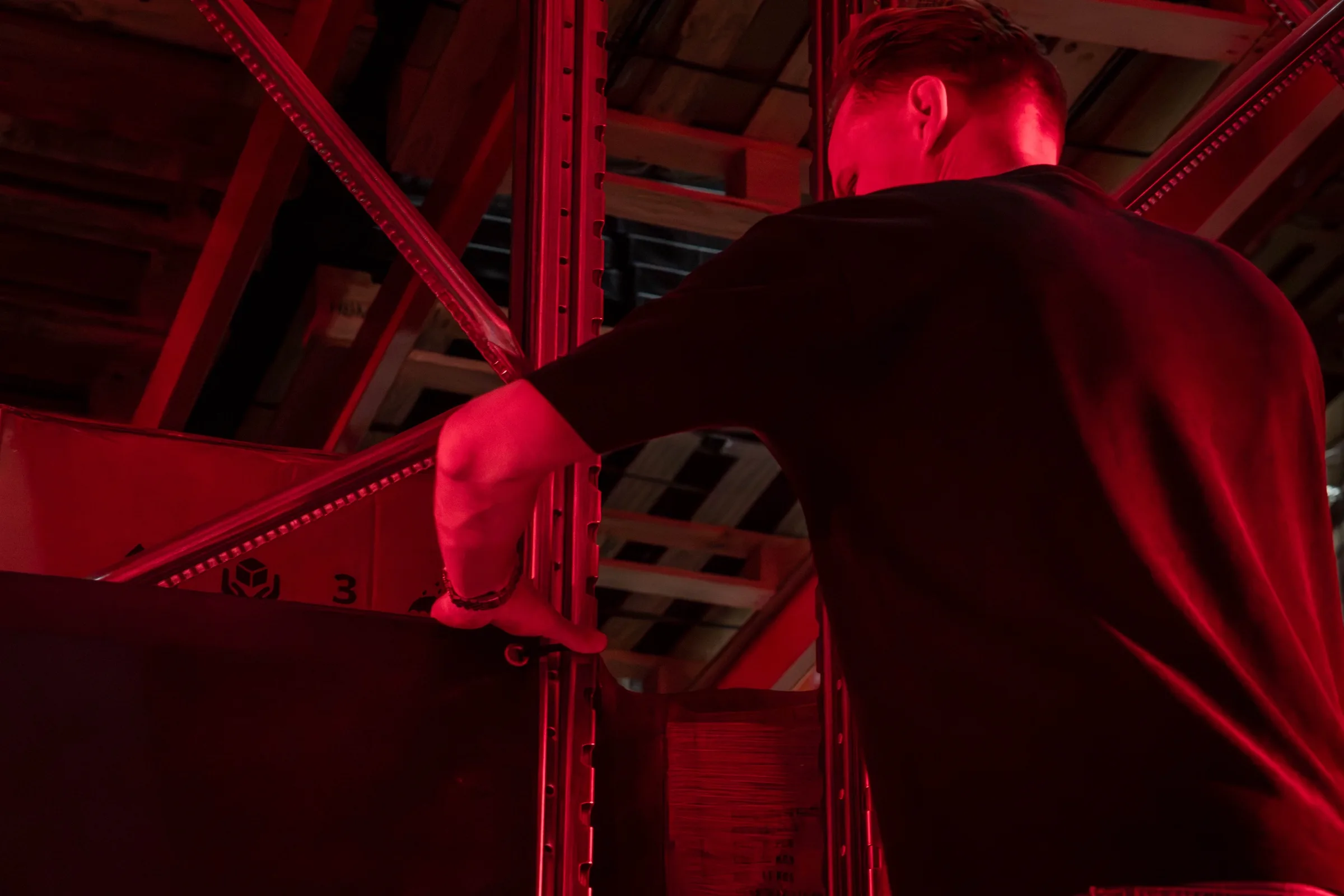 Een man in rood licht tussen de stellingen