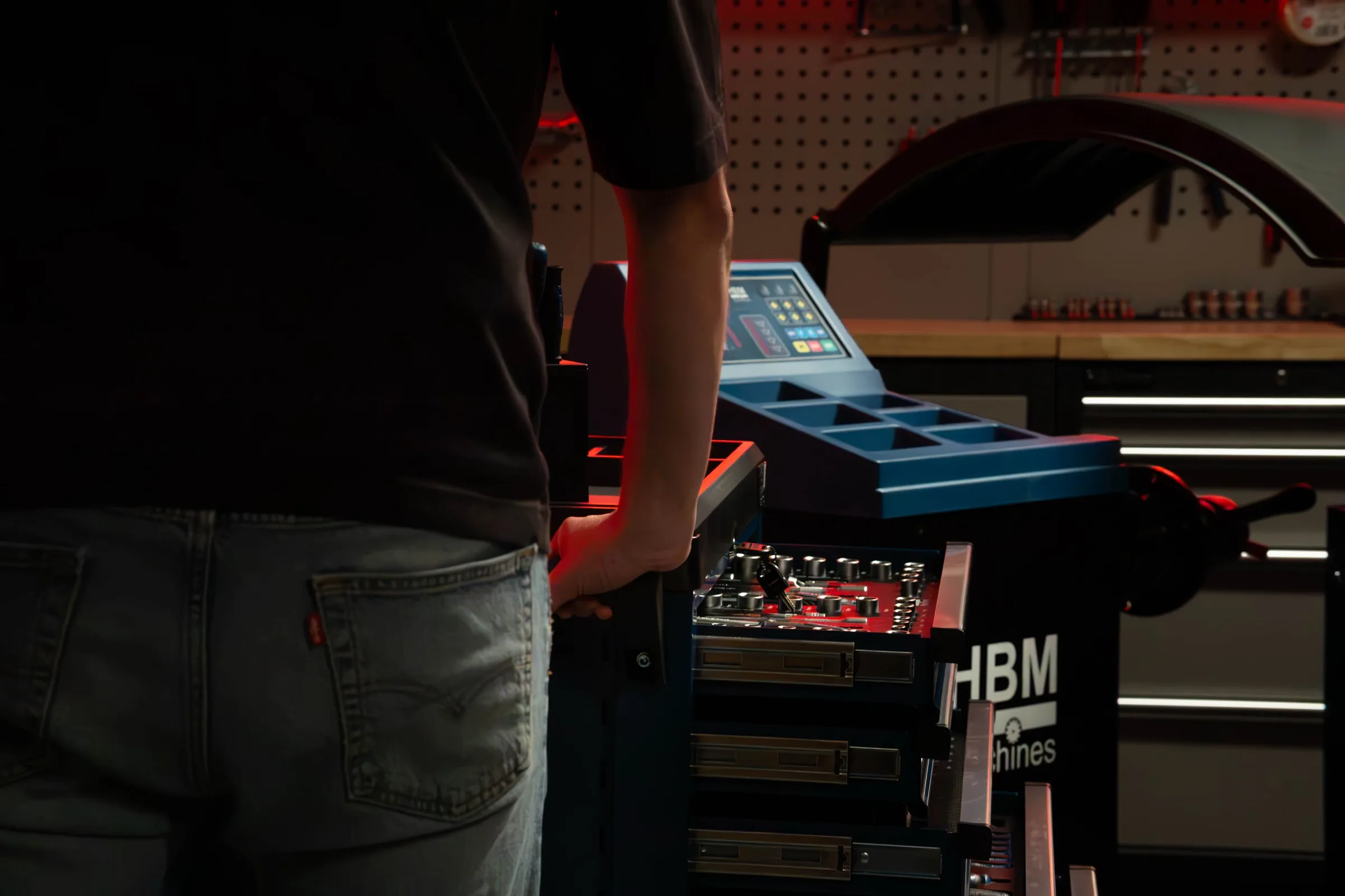 Een gereedschapswagen met HBM-logo in een werkplaats
