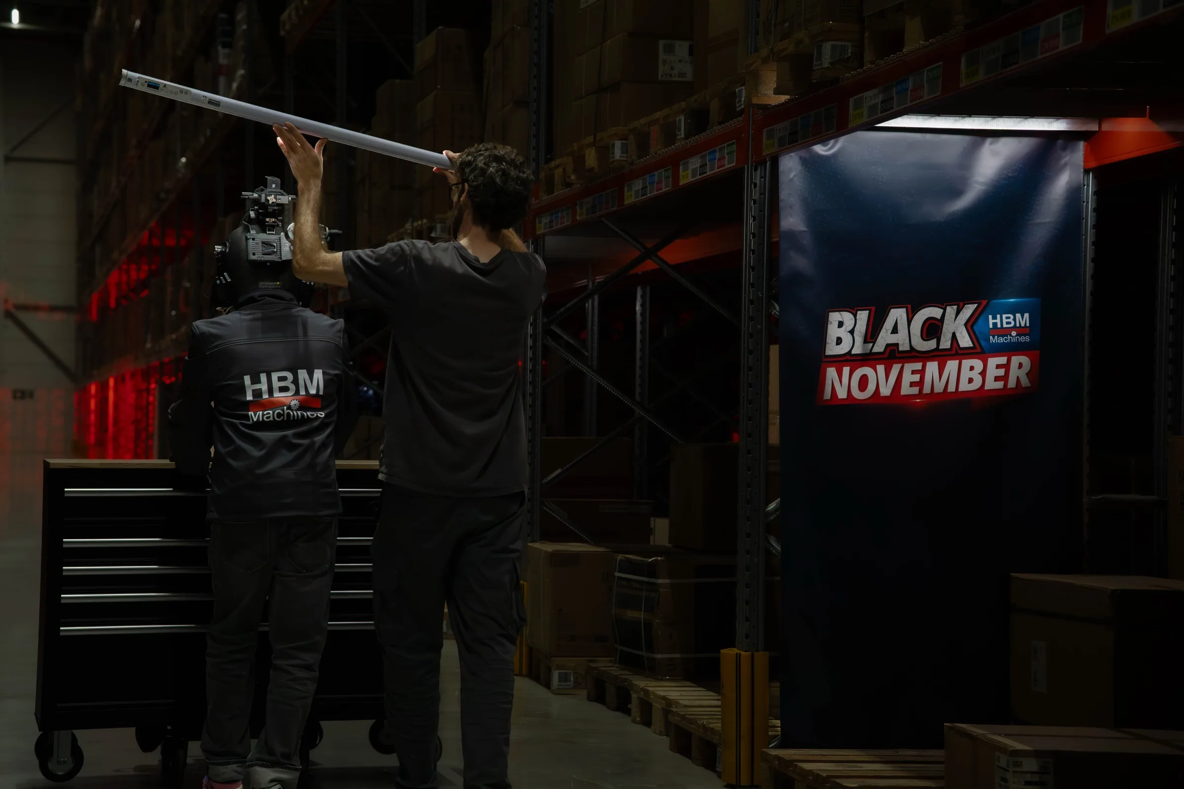 Een crewlid houdt een lamp omhoog naast een Black November-doek