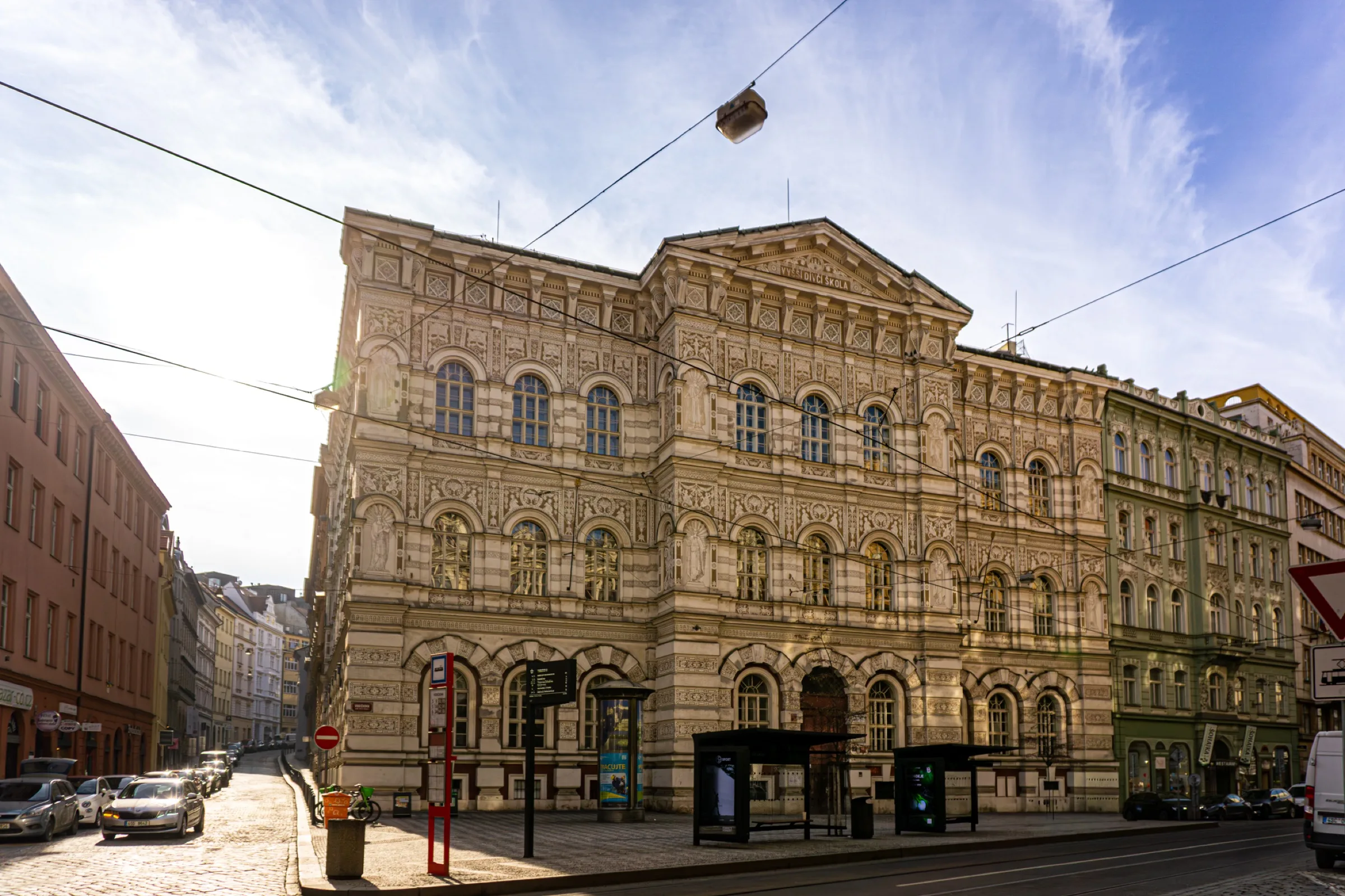 Een sierlijk oud gebouw op een straathoek onder een blauwe lucht