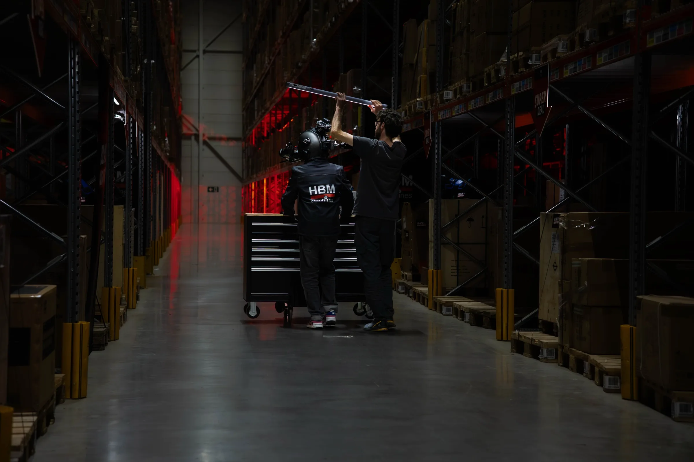 Een crew aan het werk aan het eind van een donker magazijnpad