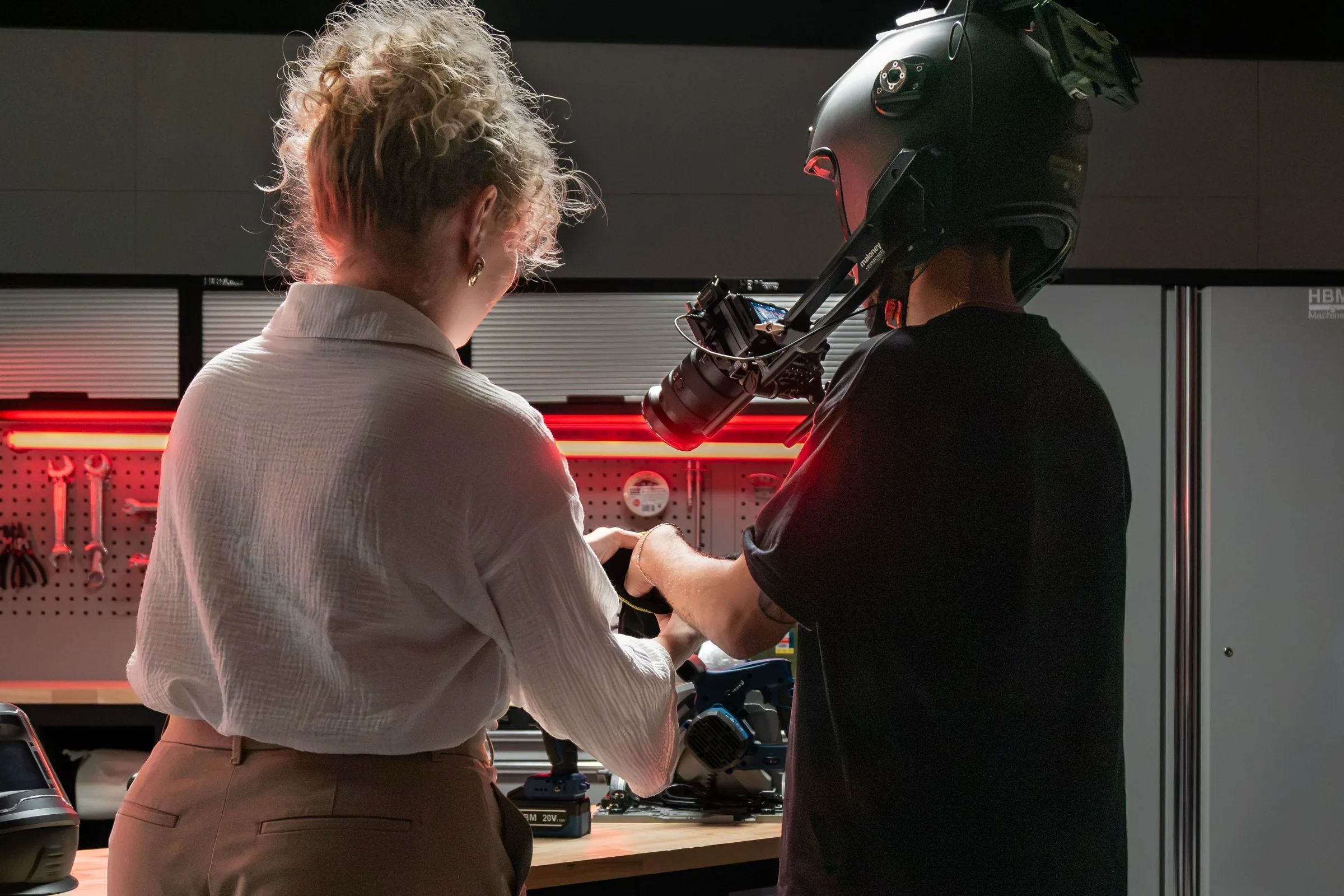 Een vrouw kijkt mee terwijl een cameraman met een helmcamera filmt