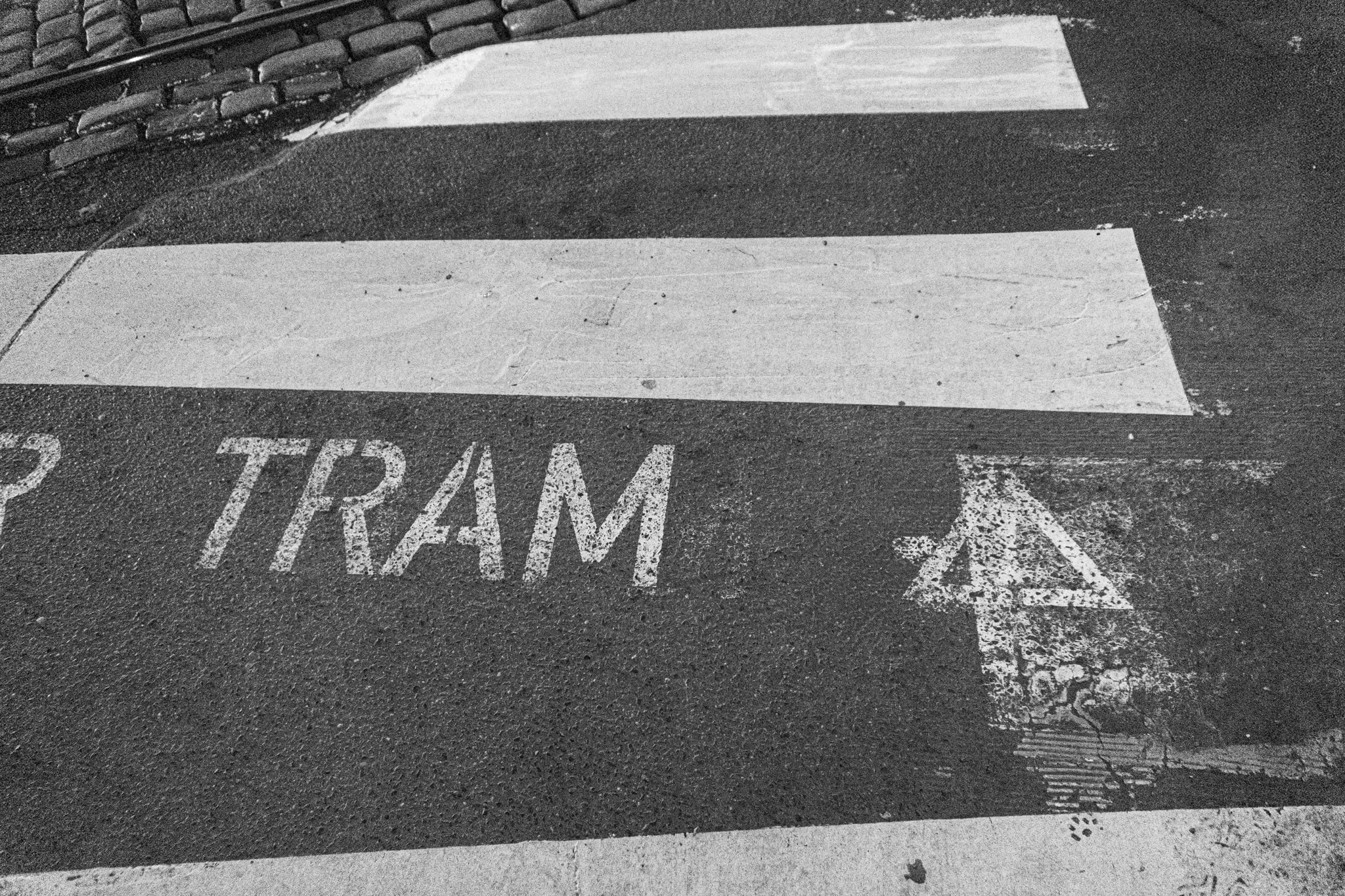 Het woord TRAM op de straat, in zwart-wit