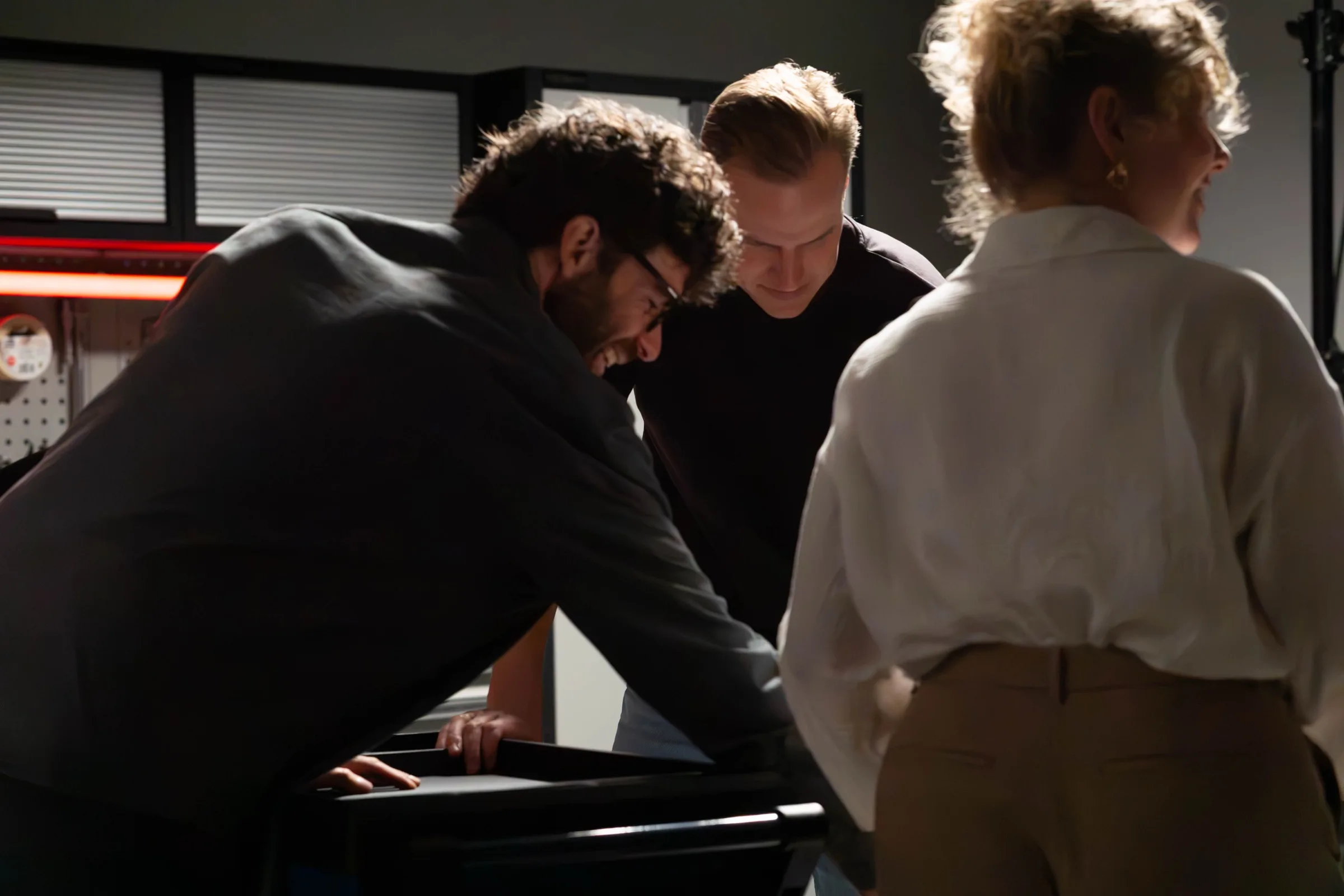 Drie mensen bekijken samen een opengeschoven gereedschapslade