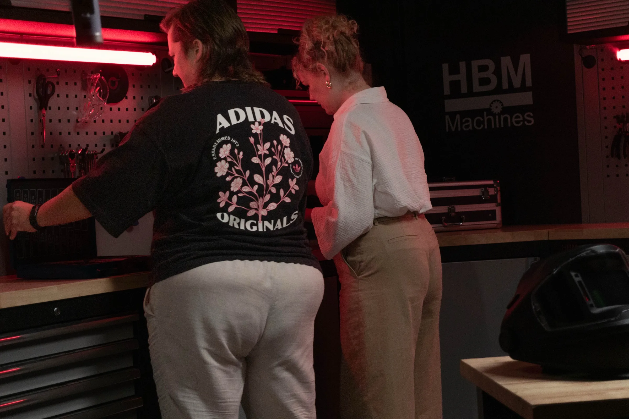 Twee mensen buigen zich over een werkbank vol gereedschap